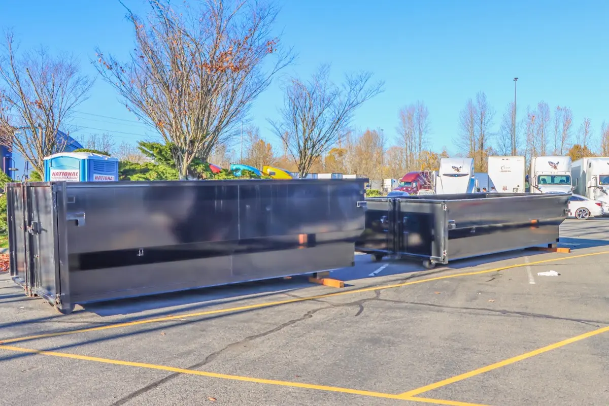 Professional dumpster rental service with roll-off container on residential driveway in Saraland